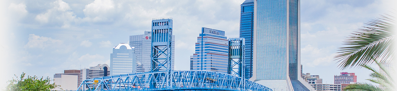 A bridge over water leads to a city skyline